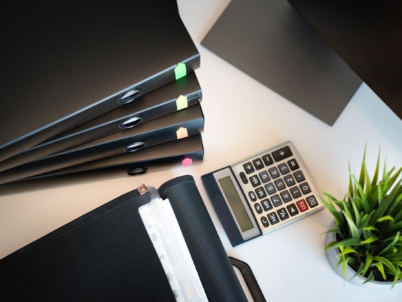 Organised desk with files, calculator and documents for rental property records