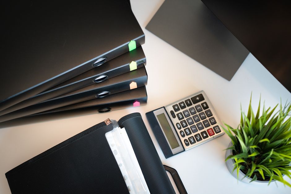 Organised desk with files, calculator and documents for rental property records