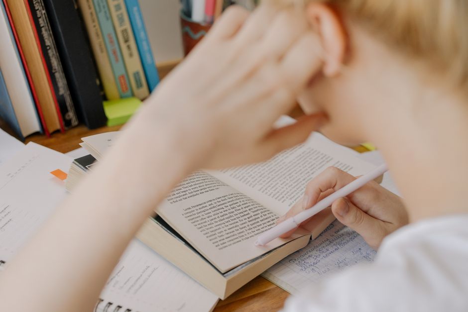 Student studying with an open textbook, preparing for a licensing exam